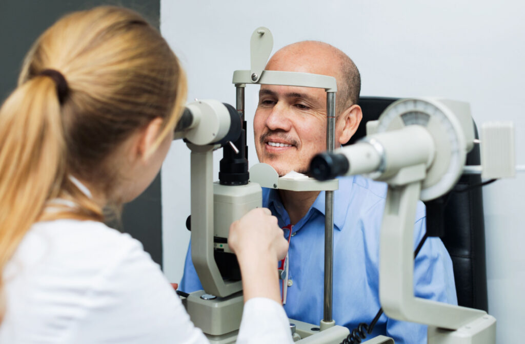 An optometrist conducting a slit lamp examination on a patient.