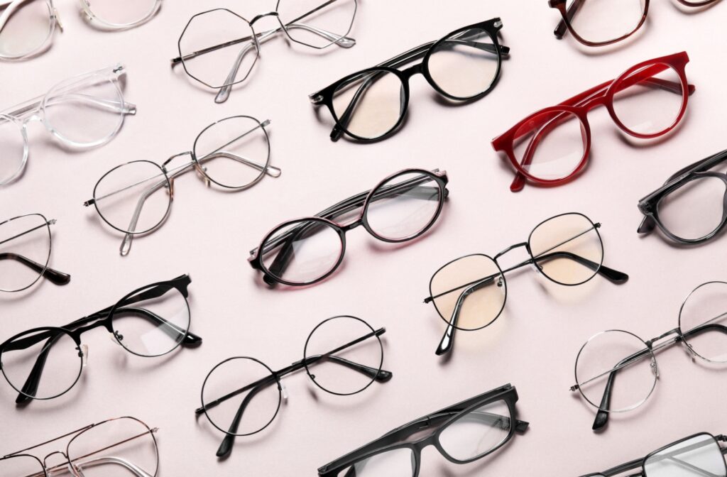 A variety of trendy glasses with different lenses sit evenly spaced out on a table